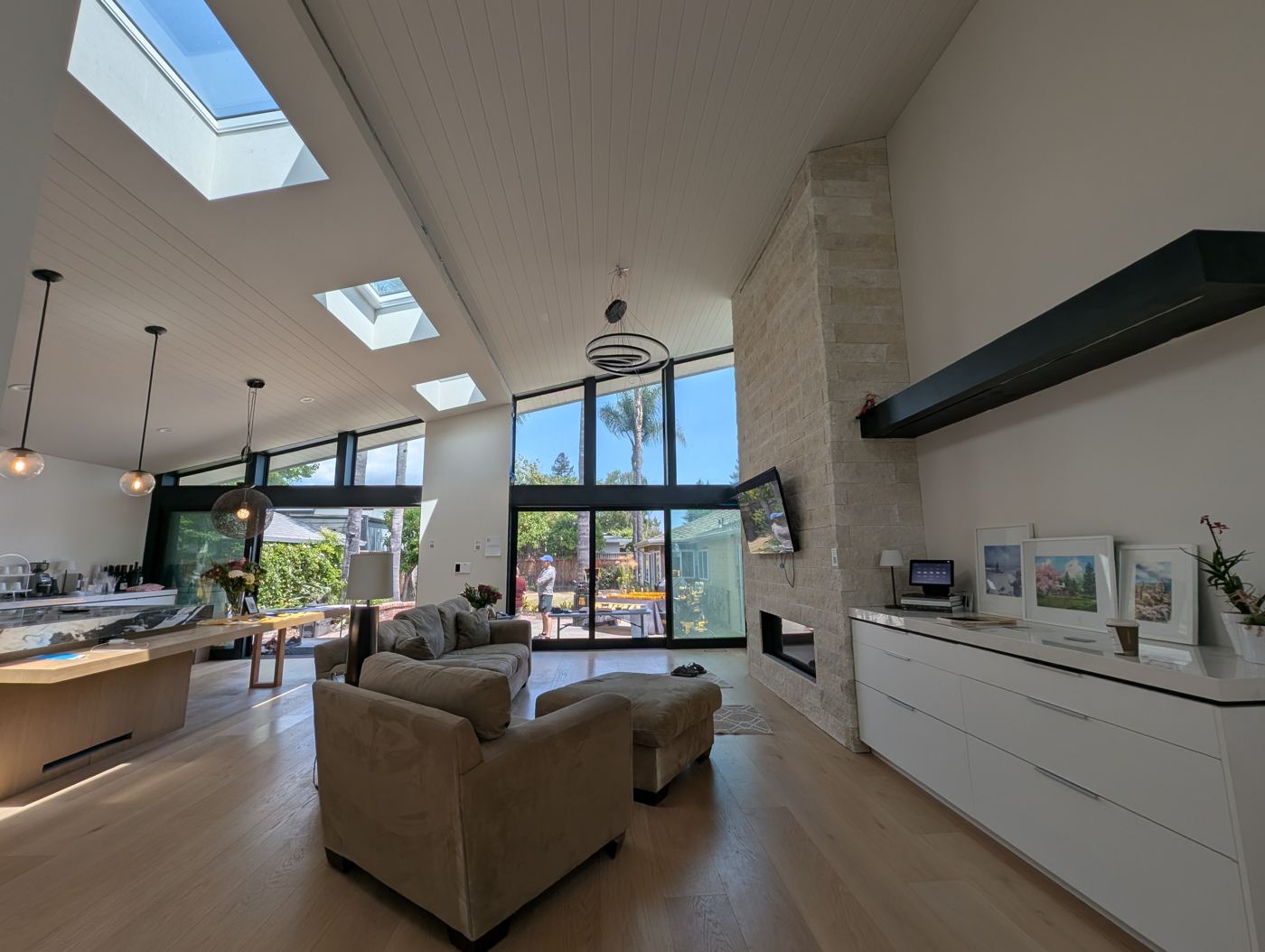 Great room with stone fireplace wall and tall windows
